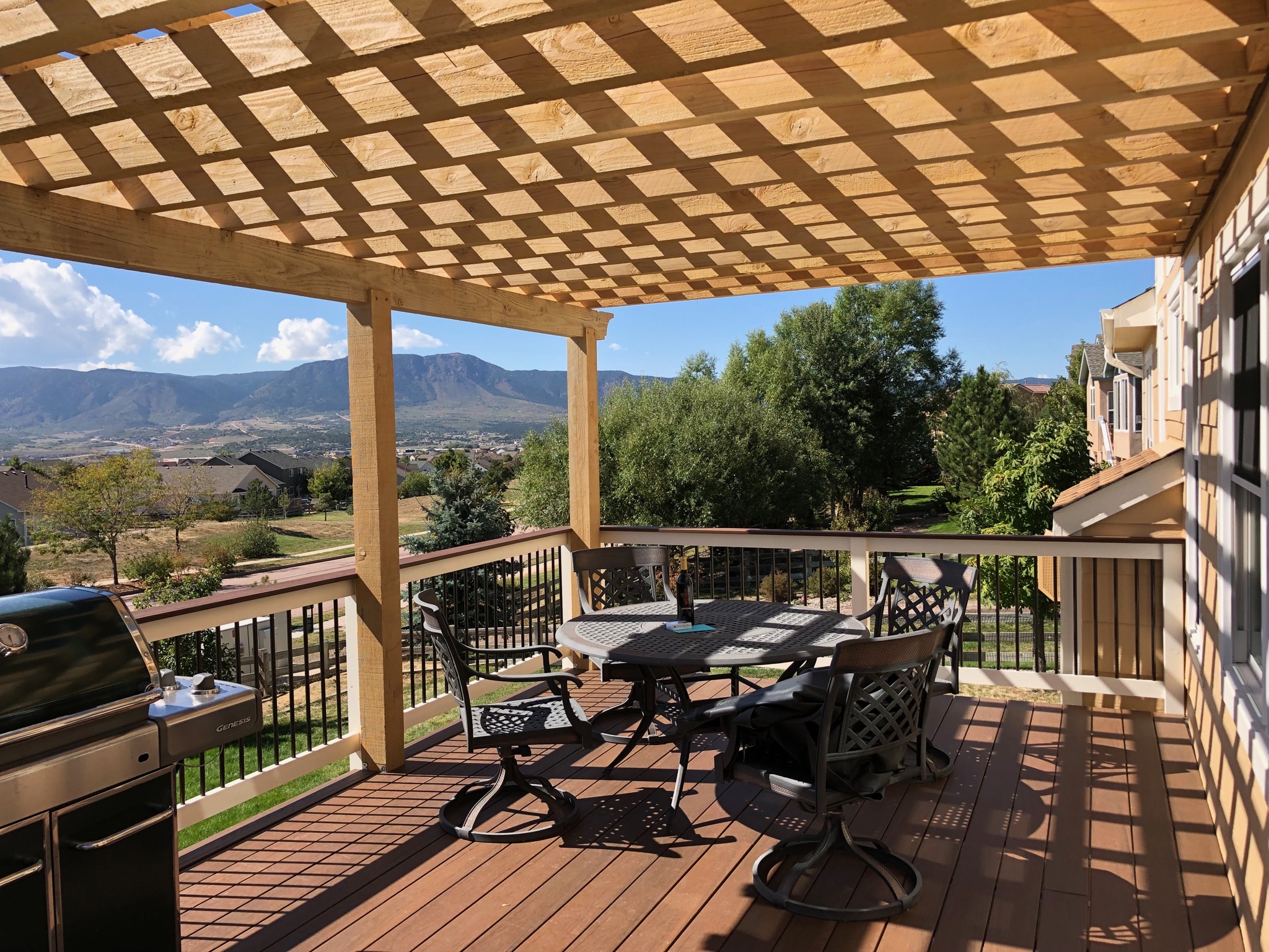 Outdoor patio with pergola and mountain view.