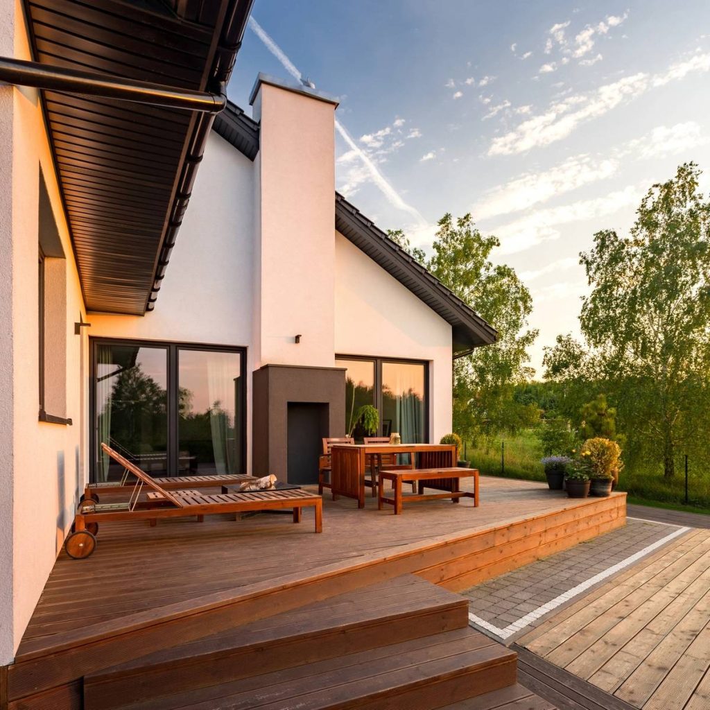 Custom composite deck beside a landscaped backyard patio